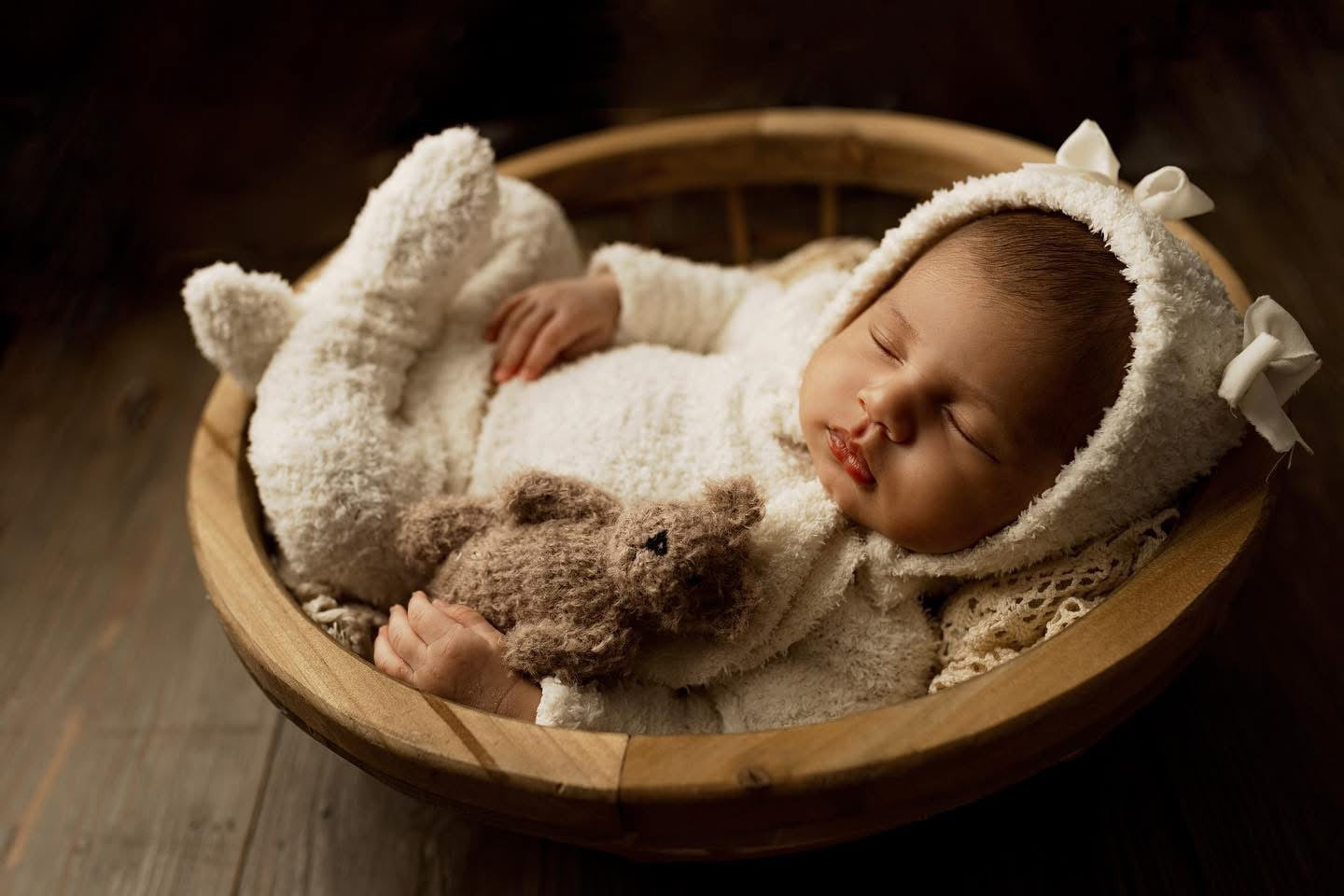 Sleeping newborn wearing handmade fuzzy bear romper with bonnet and bow, soft cream footed outfit for photography, Lily Mily Boutique.